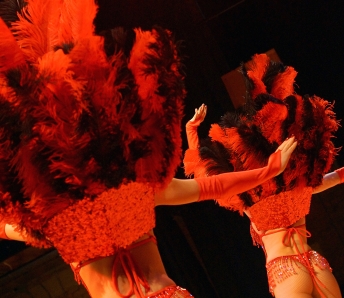 Las Vegas Showgirls  in red costumes with feather headpiece