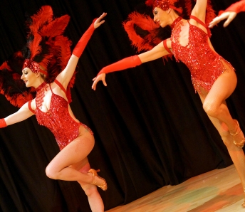 Las Vegas Showgirls  in red costumes with feather headpiece
